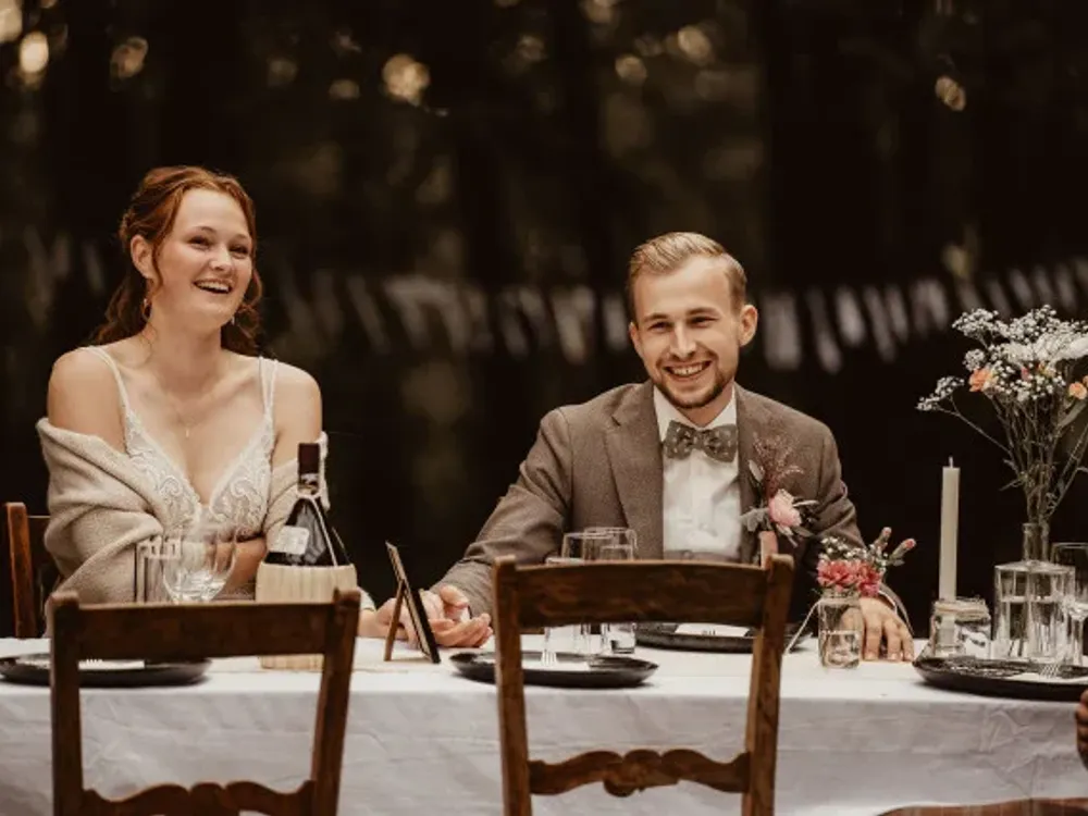 Bruidspaar lachend aan de dinertafel